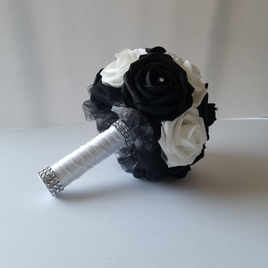 Black and white wedding bouquet made with real touch roses. Rhinestones are on the center of every rose. Handle is made up of black tulle and satin white ribbon and finished with silver bling wrap. 