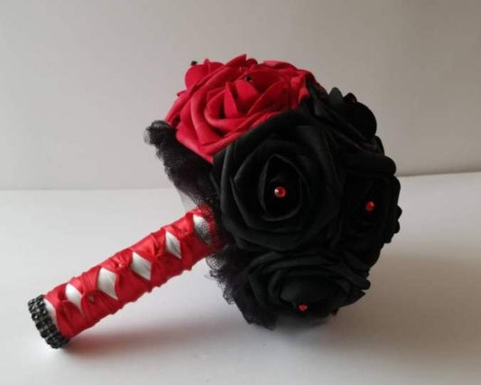 Half bouquet is red, half bouquet is black. Rhinestones in red and black rhinestones scattered throughout. Handle is made up of black tulle, Red and white ribbon in a French twist and finished with black bling wrap. 