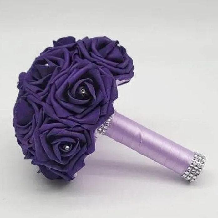 Purple and Lavender Bridal Bouquet Made with Real Touch Roses. Roses have a rhinestone on every flower. Handle is made out of lavender satin ribbon and finished with silver bling wrap. 