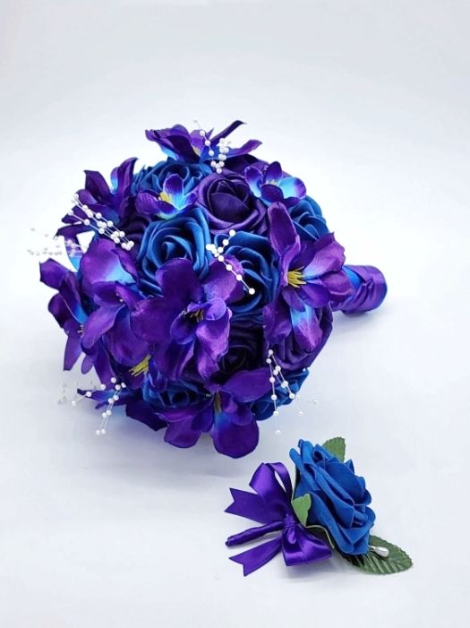 Royal blue and dark purple bridal bouquet with galaxy orchids. Handle is made using royal blue and purple ribbon in a french twist. Pearl spray is scattered around bouquet