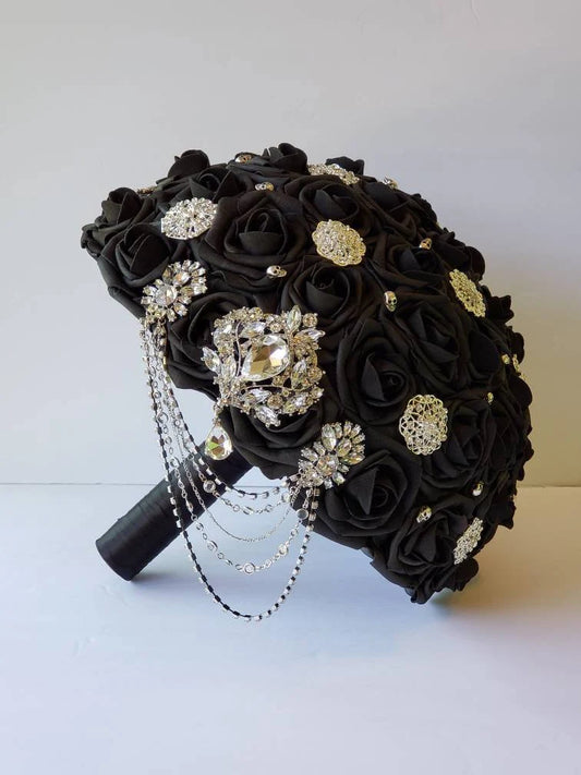 all black bridal bouquet made with real touch roses. Silver brooches and skulls are scattered all over bouquet. With silver cascading chains 