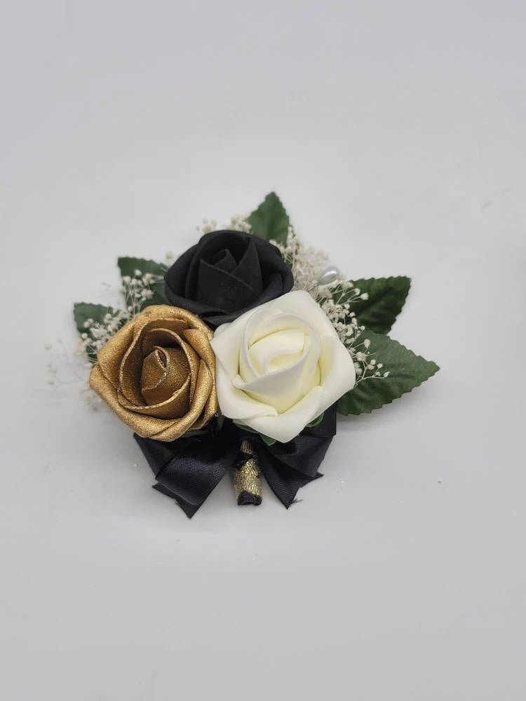 black, gold, and ivory pin on corsage with babies breath. black and gold french twist ribbon handle