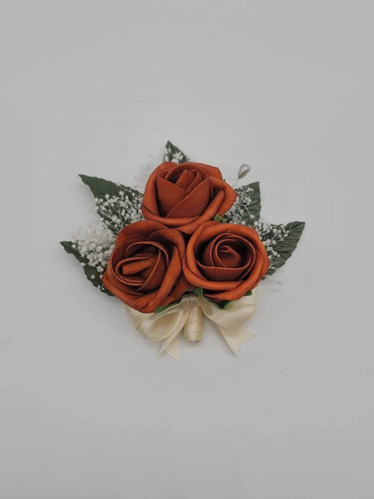 burnt orange and ivory corsage with babies breath