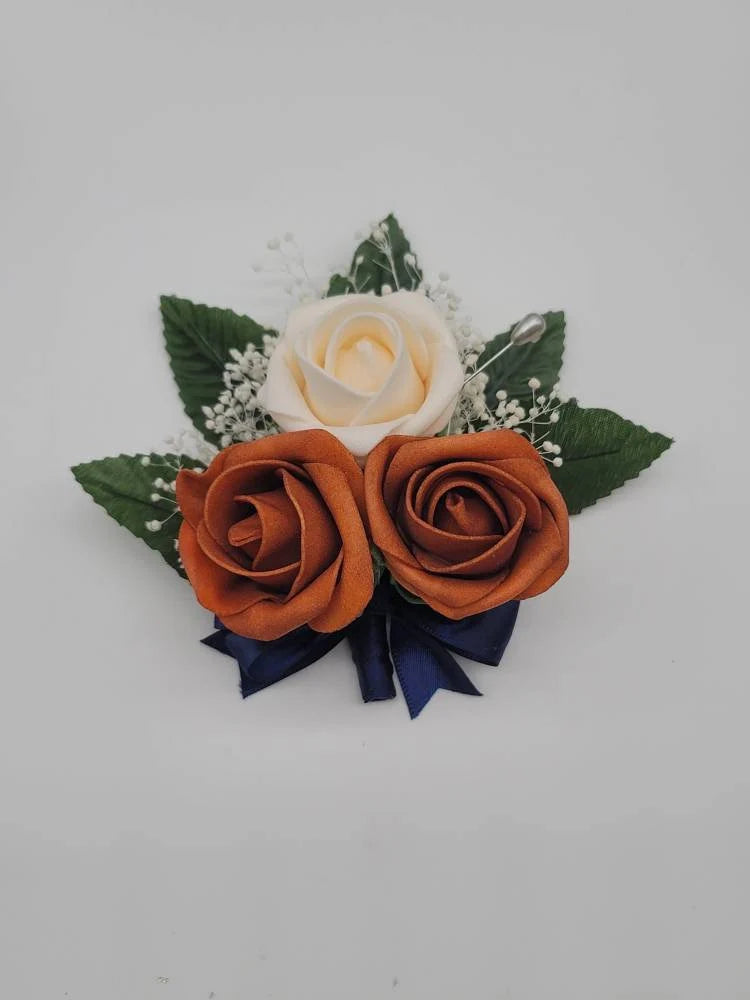 cream, burntorange pn on corsage with navy ribbon and babies breath