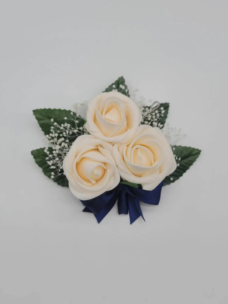 cream and navy pin on corsage with babies breath