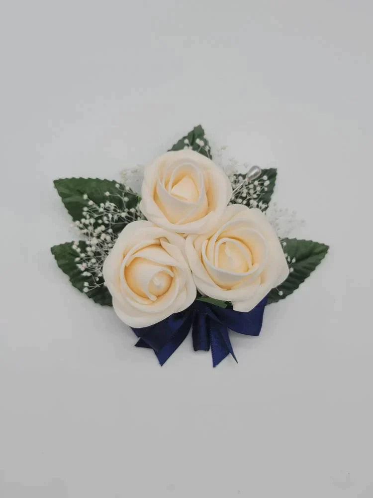 cream and navy pin on corsage with babies breath