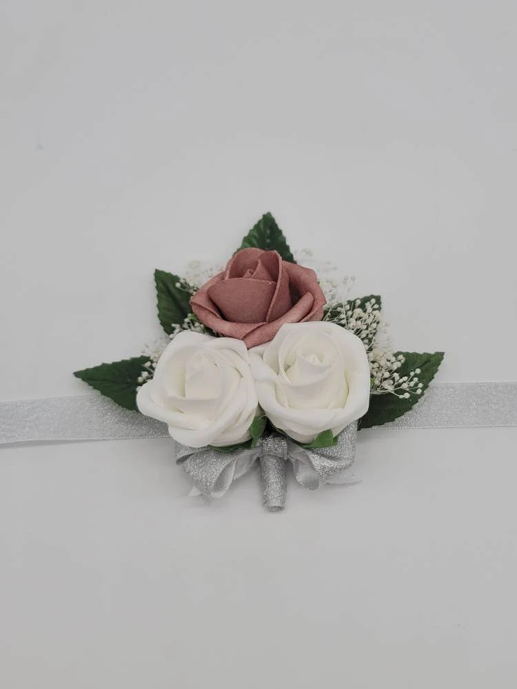 dusty rose, white, and silver wrist corsage with babies breath