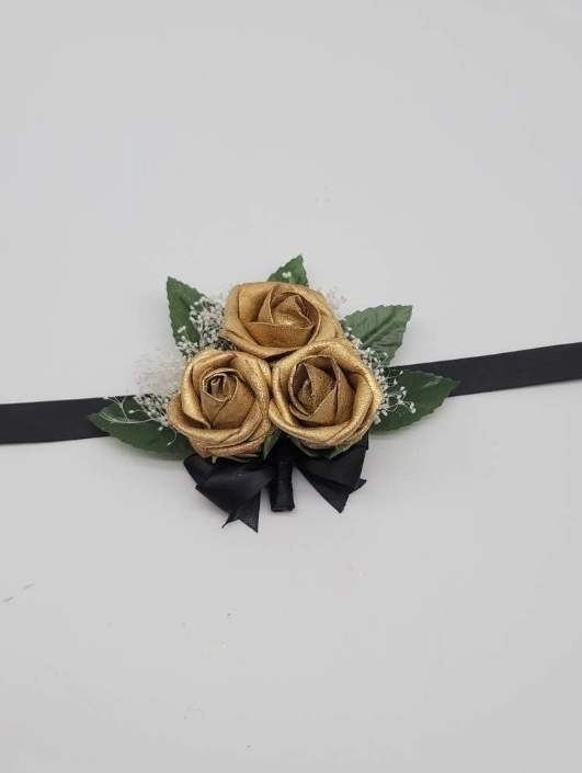 gold and black wrist corsage with babies breath