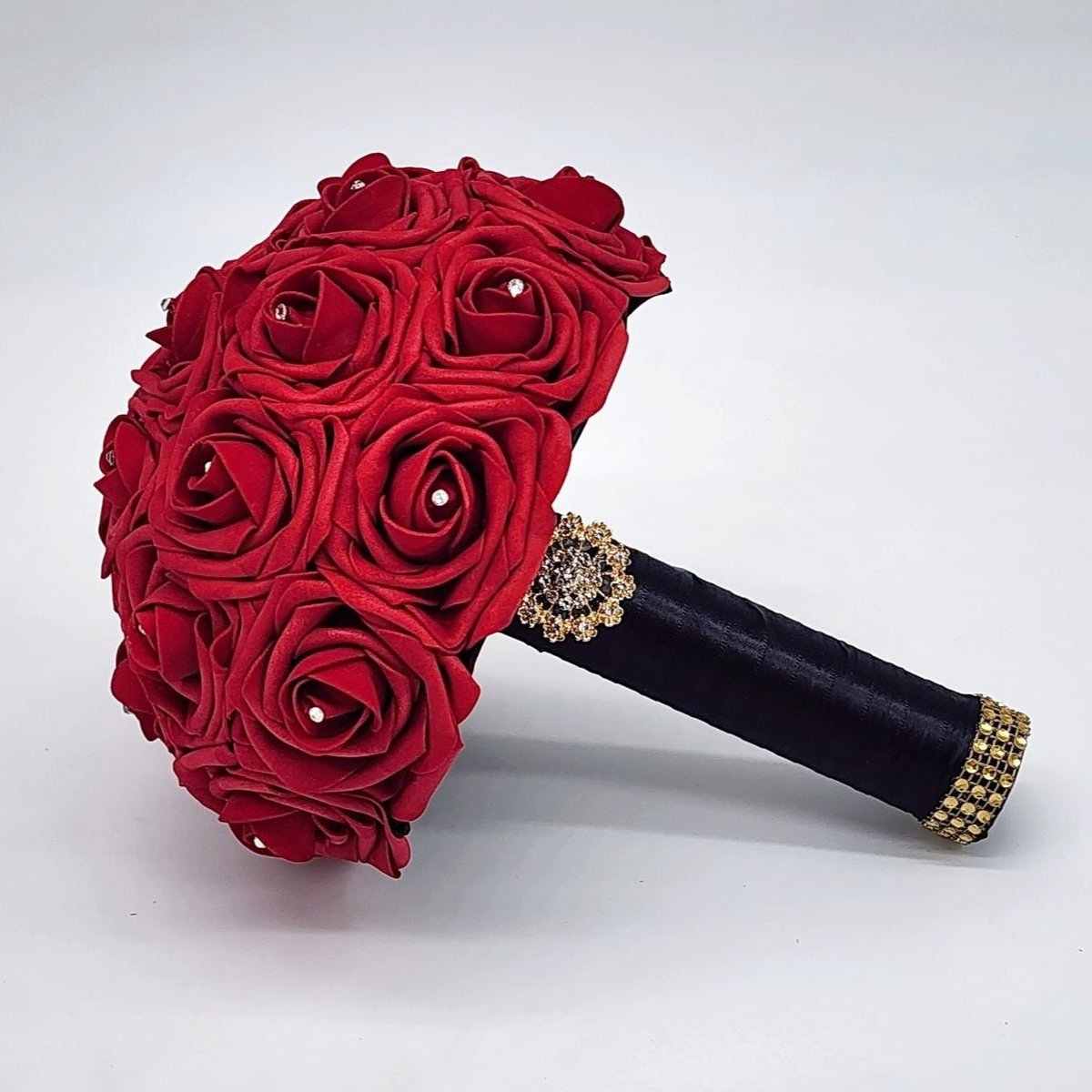 red rose bridal bouquet with rhinestones on every rose. Handle is made up of black satin ribbon and finished with a gold brooch and bling wrap. 