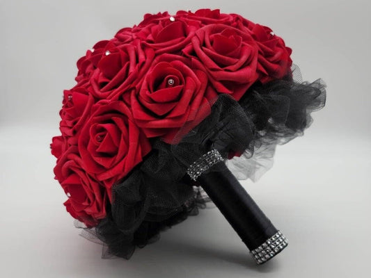 Red Real touch Roses Bridal Bouquet in 10 inch diameter. Rhinestones in center of every rose. Black tulle under flowers and finished with black satin ribbon and silver bling wrap. one strip on top of handle one on bottom of handle. 