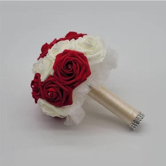 Red And Ivory Wedding Bouquet Made With Real Touch Roses. Rhinestones are placed on every rose. Handle is made up of Ivory tulle, and satin ribbon, and finished with silver bling wrap. 