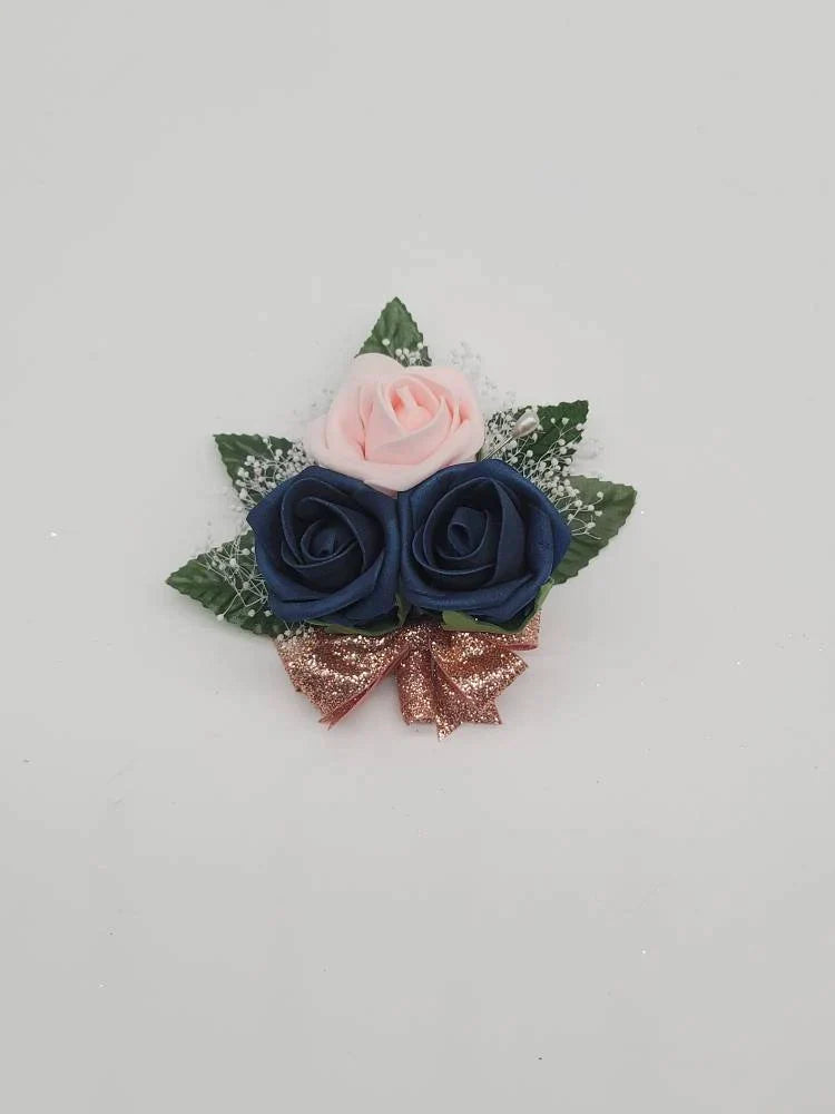 blush, navy, and rose gold pin on corsage with babies breath