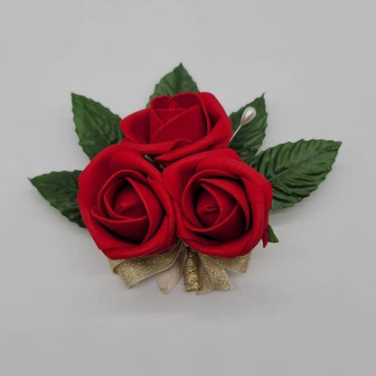 red rose pin on corsage with faux leaves and gold ribbon. Made with real touch roses